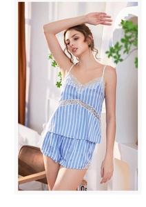 Détail de pyjama satiné à rayures bleues et blanches avec dentelle blanche et col en V profond