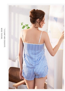Détail de pyjama en satin à rayures bleues avec bordure en dentelle sur le short et bretelles
