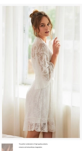 Détail d'un peignoir en dentelle blanche avec broderies florales et manches trompette