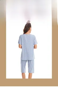 Detail of short-sleeved pajama set in light blue gingham with orange polka dot patterns