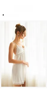 Detail view of white silk-like slip dress featuring delicate lace trim and deep V-neckline