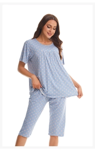 Detail view of light blue cotton pajamas with pink polka dots and white plaid patterns