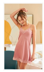 Détail de l'encolure en dentelle sur la nuisette en soie mauve et fines bretelles