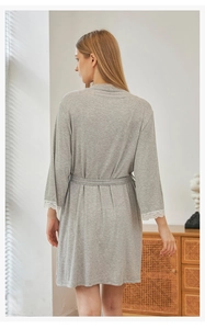 Detail of grey modal knit robe with white lace trim on sleeves and adjustable waist tie