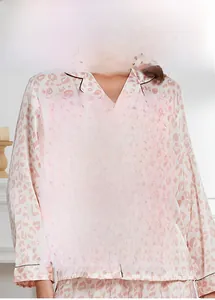 Detail view of pink leopard satin pajamas featuring black piping and premium silk texture