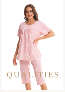 Detail of pink cotton pajamas with white heart prints and grape lettering for women