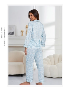 Detail of light blue leopard print silk pajamas set with black piping in home setting
