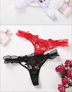Présentation à plat de strings en dentelle rouge, noir et blanc avec roses et parfum