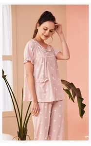 Detail of pink striped pajamas with white ruffle trim and delicate heart patterns