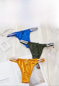 Detailed view of satin thongs in royal blue, emerald green and mustard with bow accents