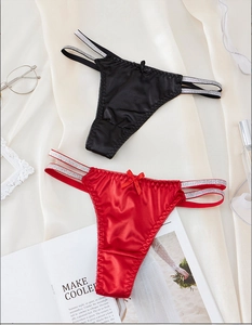 Detail of red and black satin lace thongs with shimmering straps and small bows