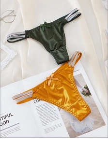Detail view of satin lace thongs in ginger and dark green with silk side straps