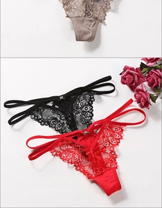 Detail of floral lace texture and thin straps on sexy thong with metal ring buckles