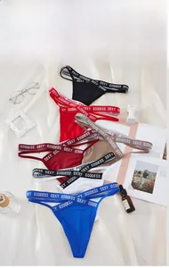 Flat lay of colorful lace thong underwear with Sexy Goddess lettered elastic waistband
