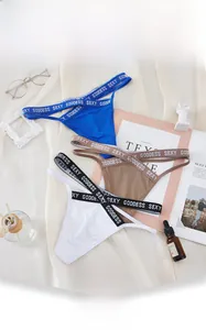 Detailed close-up of colorful thongs with Sexy Goddess lettering and mesh fabric texture