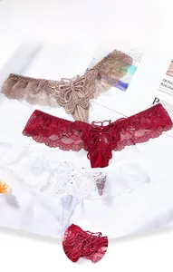 Detailed close-up of lace thongs with butterfly embroidery and crystal accents