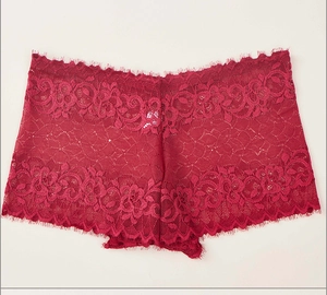 Détail macro de la dentelle florale et des bords en dentelle cils sur ce shorty rouge foncé