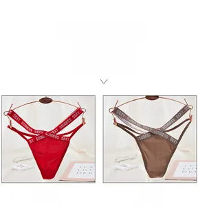 Detail of red and brown lace thongs featuring SEXY GODDESS letters and cross straps