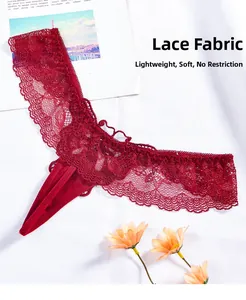 Close-up of red lace thong featuring fine mesh texture and scalloped edges on white fabric