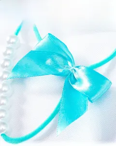 Détail d'un nœud en satin sarcelle avec perles élégantes et élastique de décoration