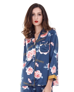 Detail of navy silk pajama set featuring pink roses and dreams script text with piping