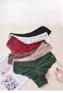 Vue à plat de plusieurs culottes en dentelle avec broderie florale et bords festonnés