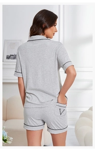 Detail of light gray loungewear set with black piping and V letter on back pocket