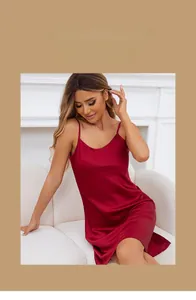 Detail view of a luxurious red satin nightdress with thin shoulder straps and smooth texture