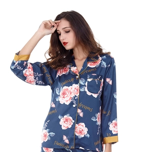Detail of satin pajama top featuring pink roses, butterfly prints and gold piping