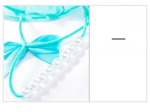 Détail d'un string en dentelle bleu canard avec perles lisses et nœud en soie doux