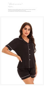 Detail of black modal pajamas with short sleeves, lapel collar, and white contrast piping