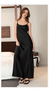 Detail of elegant black silk slip nightdress with high side slit and smooth satin texture