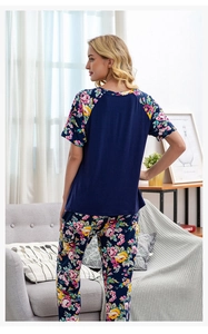 Details von geblümten Ärmeln und Hosen an einem weichen Baumwollstrick-Pyjama-Set