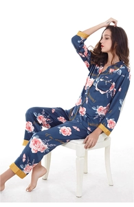 Detail of silk satin pajamas featuring pink roses, butterflies, and golden contrast trim