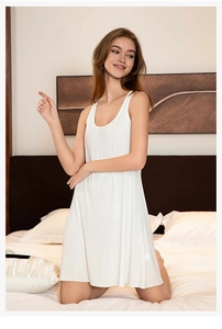 Detailed texture of white sleeveless lounge dress in soft ribbed viscose fabric on bed