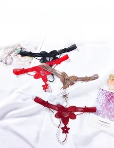 Close-up of floral lace thongs set with pearl string detailing in various colors