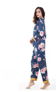 Detailed close-up of dark blue silk satin pajamas featuring floral prints and contrast piping