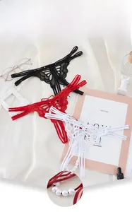 Détail du string en dentelle avec broderie papillon et décor de perles élégantes