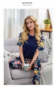 Detail eines dunkelblauen Pyjama-Sets mit Blumendruck an Ärmeln und passender langer Hose