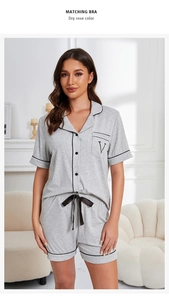 Detail of grey modal cotton pajama set with black trim, buttons, and V embroidery