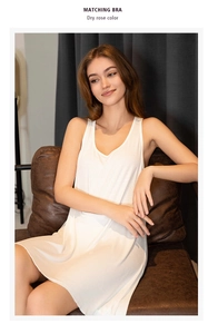 White sleeveless viscose nightdress with scoop neck shown in a cozy home setting