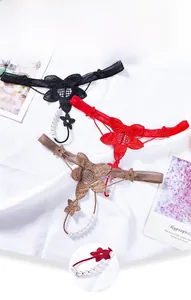 Detailed view of lace thongs with floral patterns and delicate pearl accents in three colors
