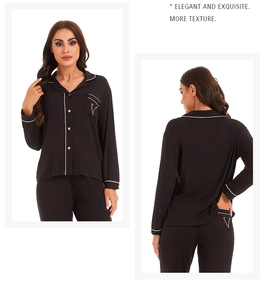 Detail view of black pajamas set with contrast white piping and V-letter embroidery