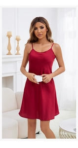 Luxurious red satin slip dress with thin straps, shown in a cozy home lifestyle setting
