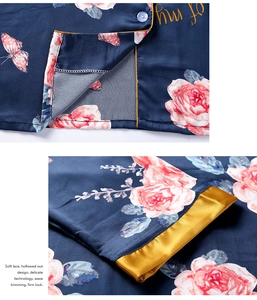 Detail of silk satin pajama cuff with floral rose print and golden piping border