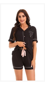 Detail of black modal pajamas featuring pink piping, chest V-embroidery, and satin waist tie