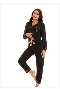 Close-up of black modal pajama detail with white piping and pink satin drawstring