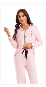 Detail of pink modal pajama set showing the black piping and V-embroidered pocket