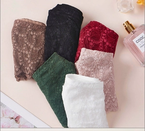Détail de six culottes en dentelle en marron, noir, bordeaux, vert, rose et blanc