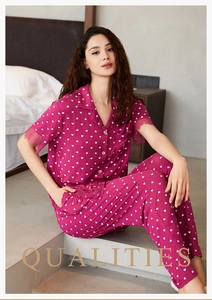 Detail eines fuchsiafarbenen Pyjama-Sets mit Herzmuster und feiner Spitze am Saum